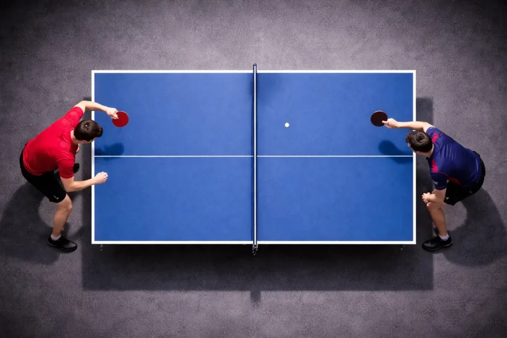 Vista cenital de una mesa de tenis de mesa con la red en el centro durante un partido
